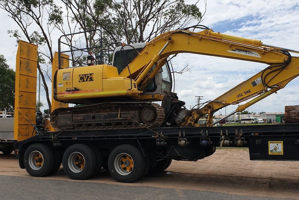 A Yellow Excavator is Sitting on Top of a Flatbed Truck — Beehive Property Maintenance in Emerald, QLD