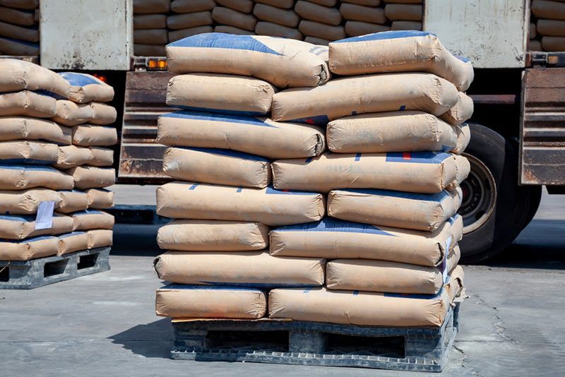 Bags of Cement Are Stacked on Top of Each Other on a Pallet — Beehive Property Maintenance in Emerald, QLD