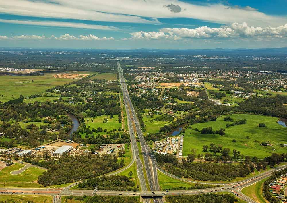 An Aerial View of a Highway Going Through a Lush Green Countryside — Beehive Property Maintenance in Comet, QLD