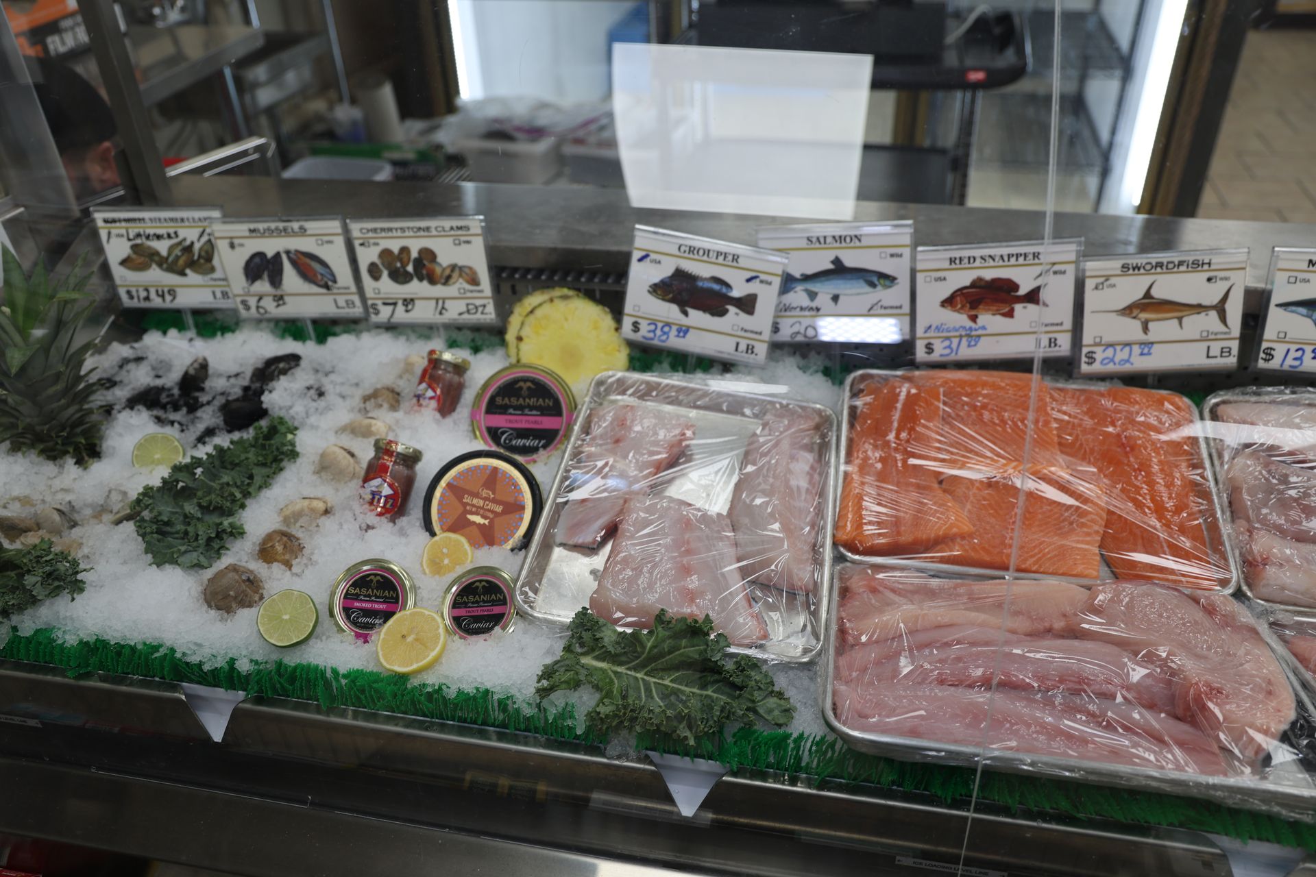A display case filled with lots of different types of fish and seafood.