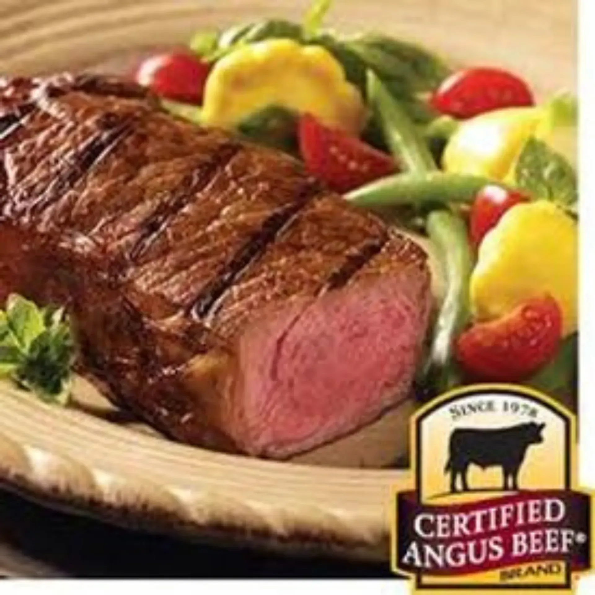 A certified angus beef steak with vegetables on a plate