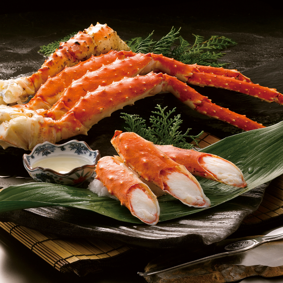 A large crab is sitting on a leaf on a plate.