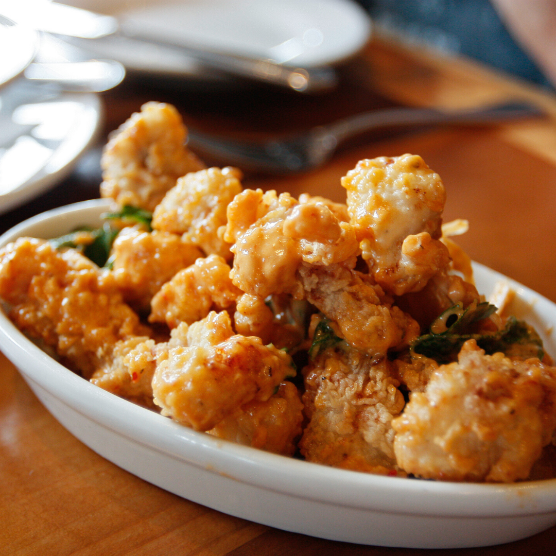 A white bowl filled with fried food on a table