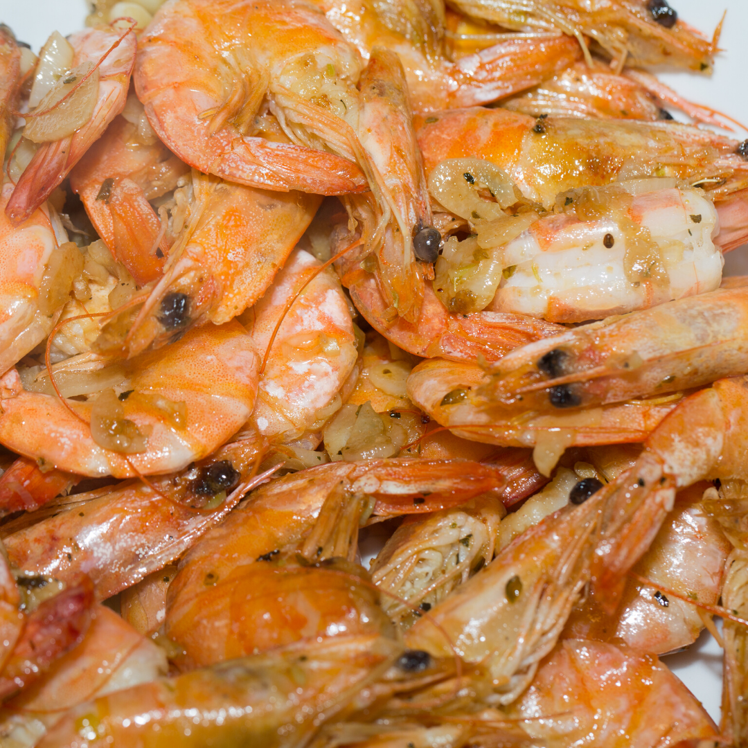 A pile of shrimp is sitting on a white plate.