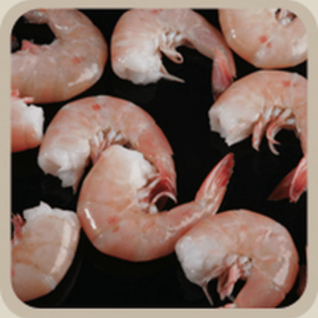 A pile of cooked shrimp on a black surface