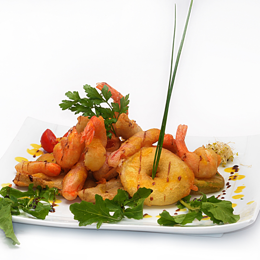 A white plate topped with shrimp and a pineapple ring