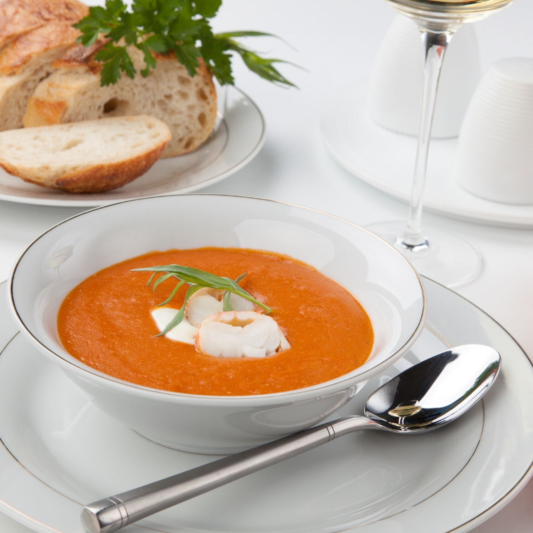 A bowl of soup with a spoon on a plate