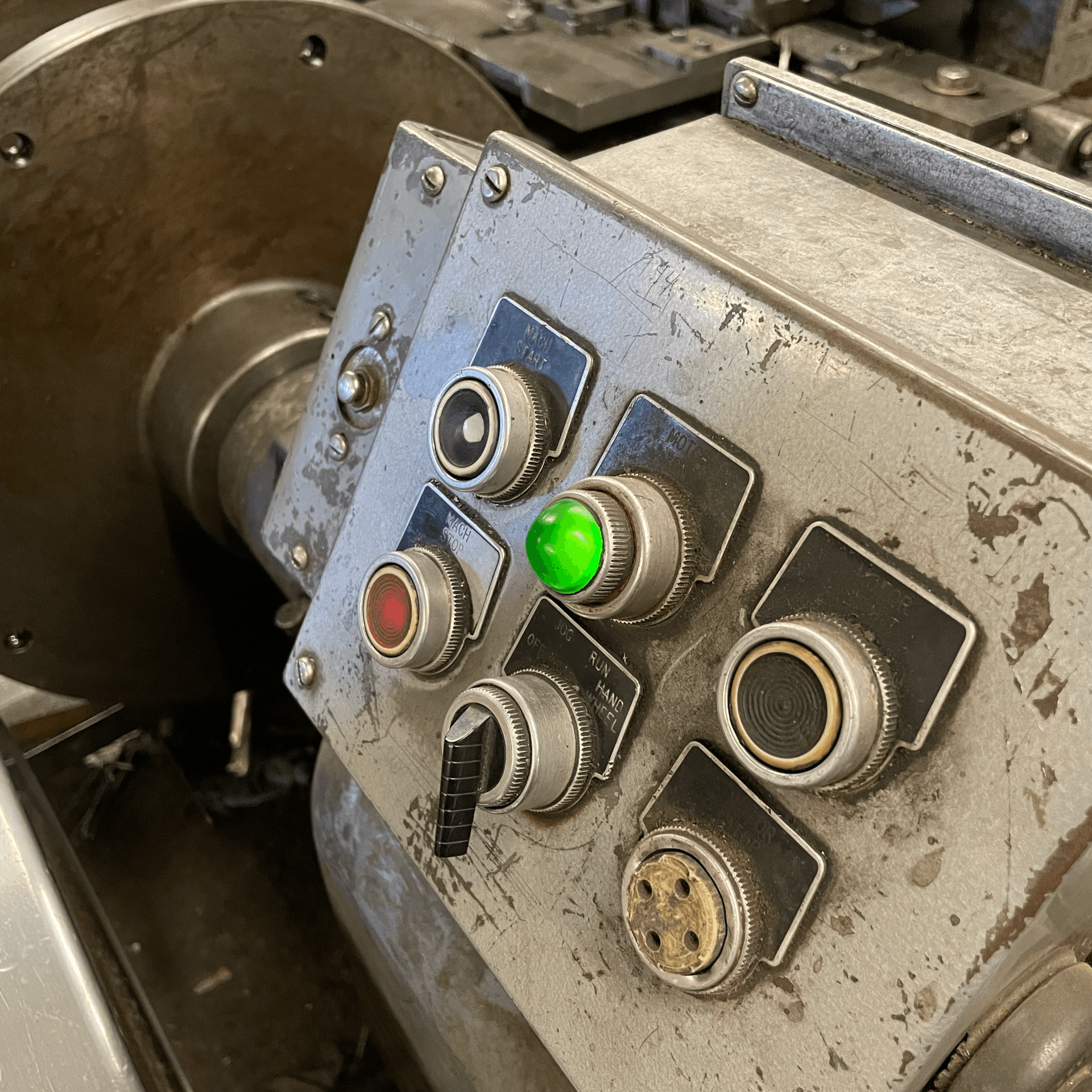 A close up of a control panel on a machine with a green light on it.