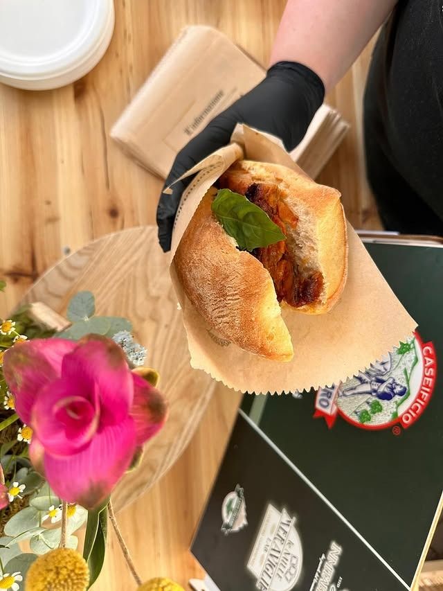 Due rotoli di formaggio bianco e fette di prosciutto con ripieno cremoso, su un tagliere di legno, vetrina per la carne.