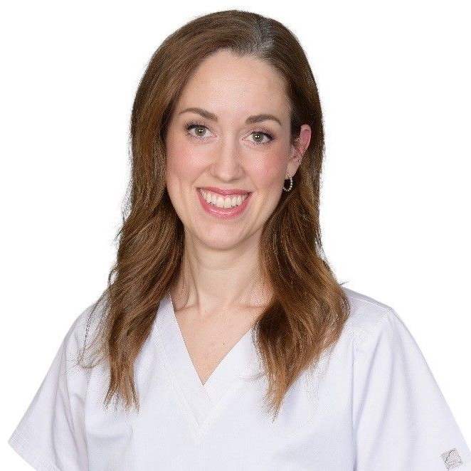 Leende tandläkare i vit rock mot en vanlig vit bakgrund