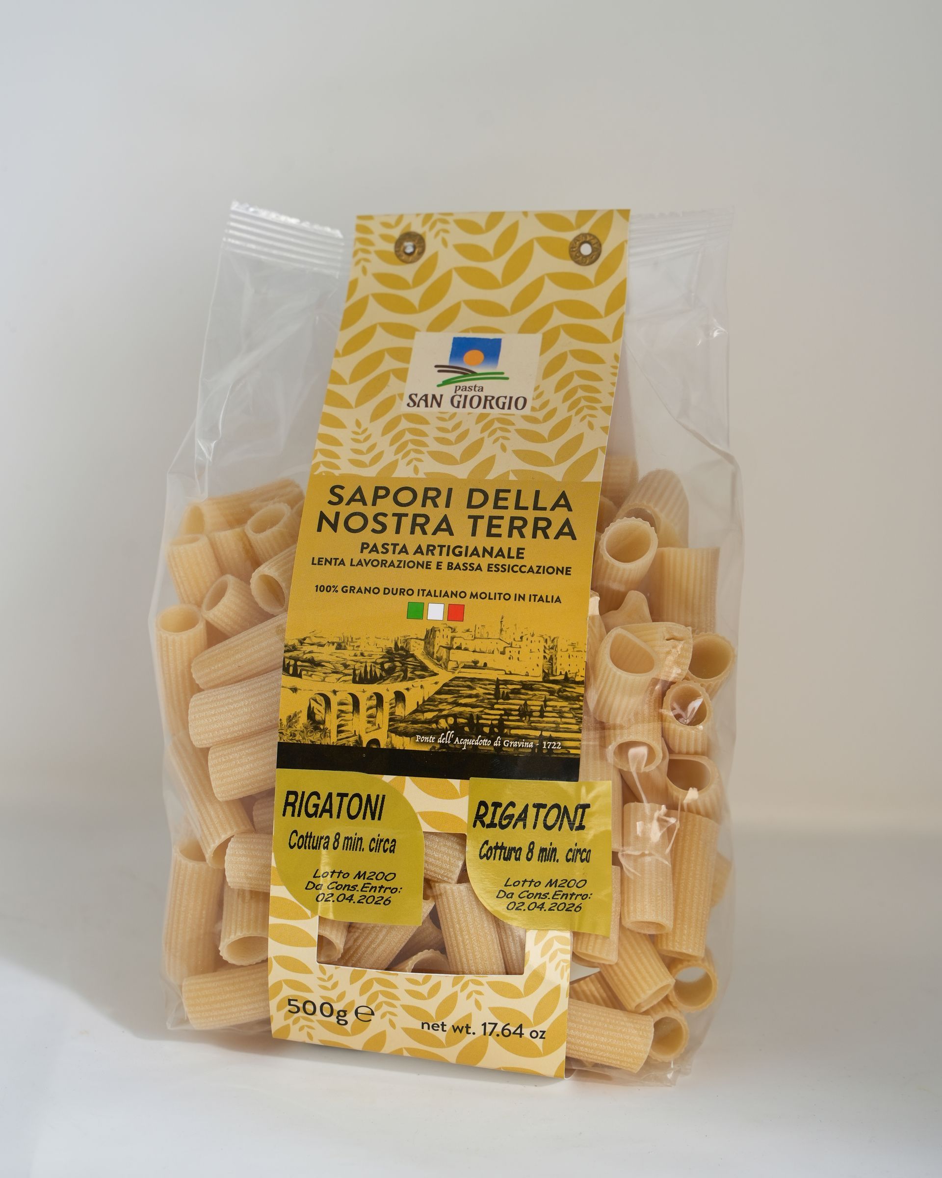 Sacchetto di pasta rigatoni con etichetta gialla e verde.
