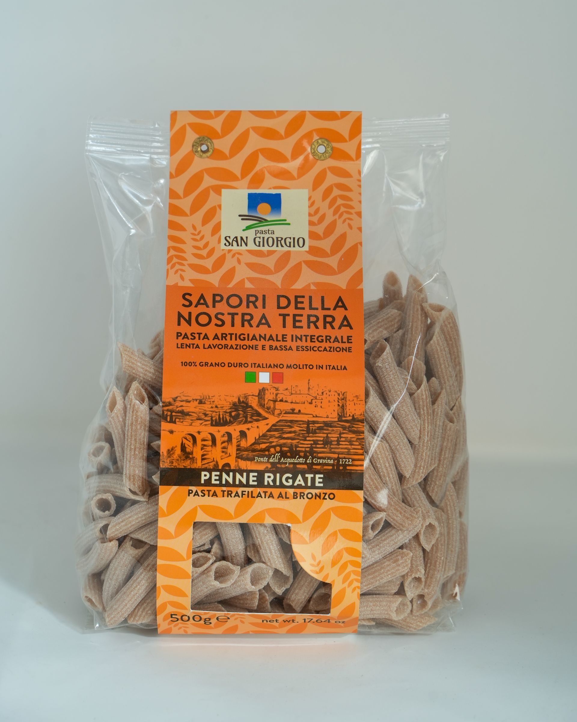 Bag of penne rigate pasta with orange label; Italian flag, text 