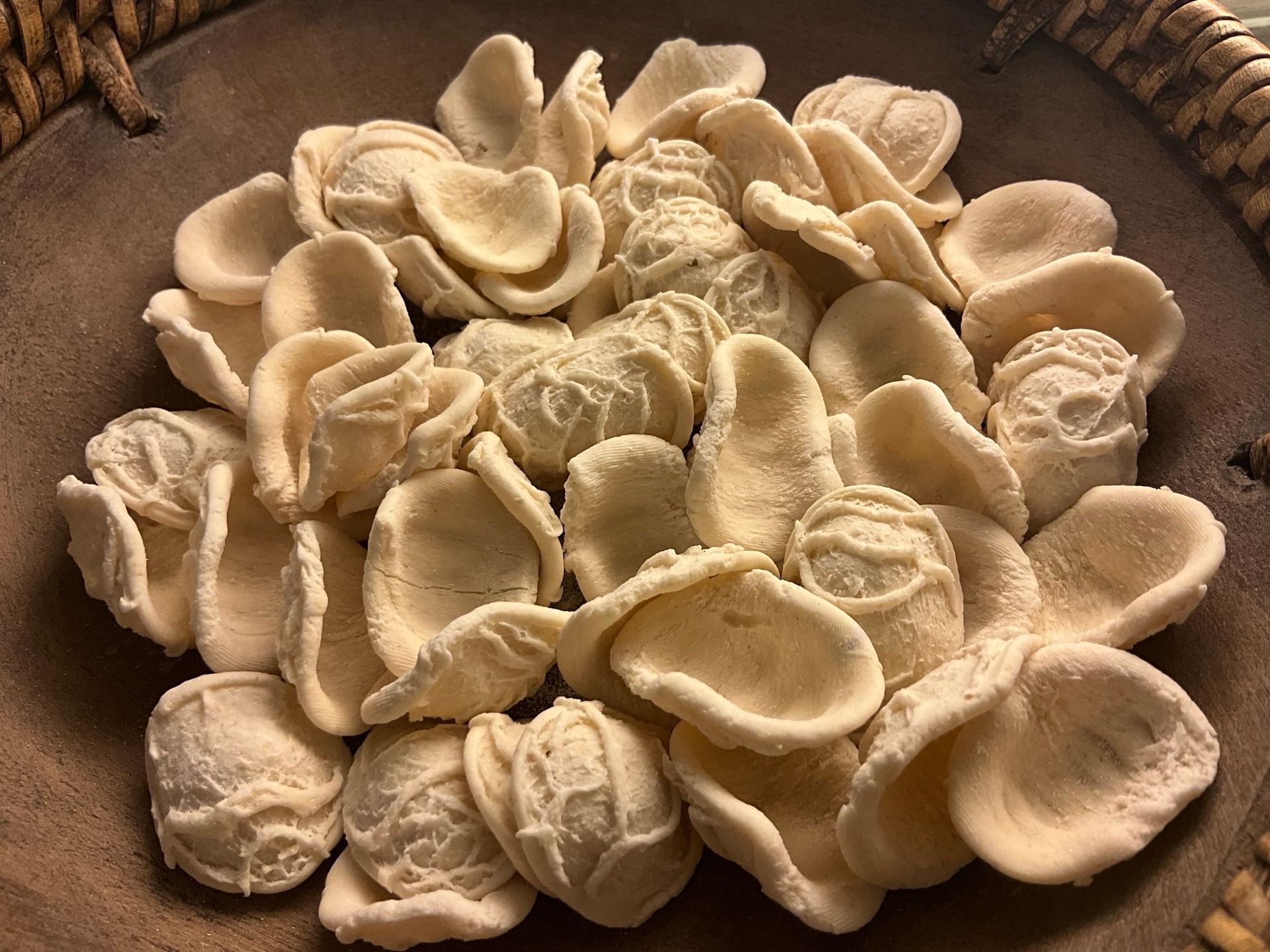 Mucchio di orecchiette in una ciotola di legno.