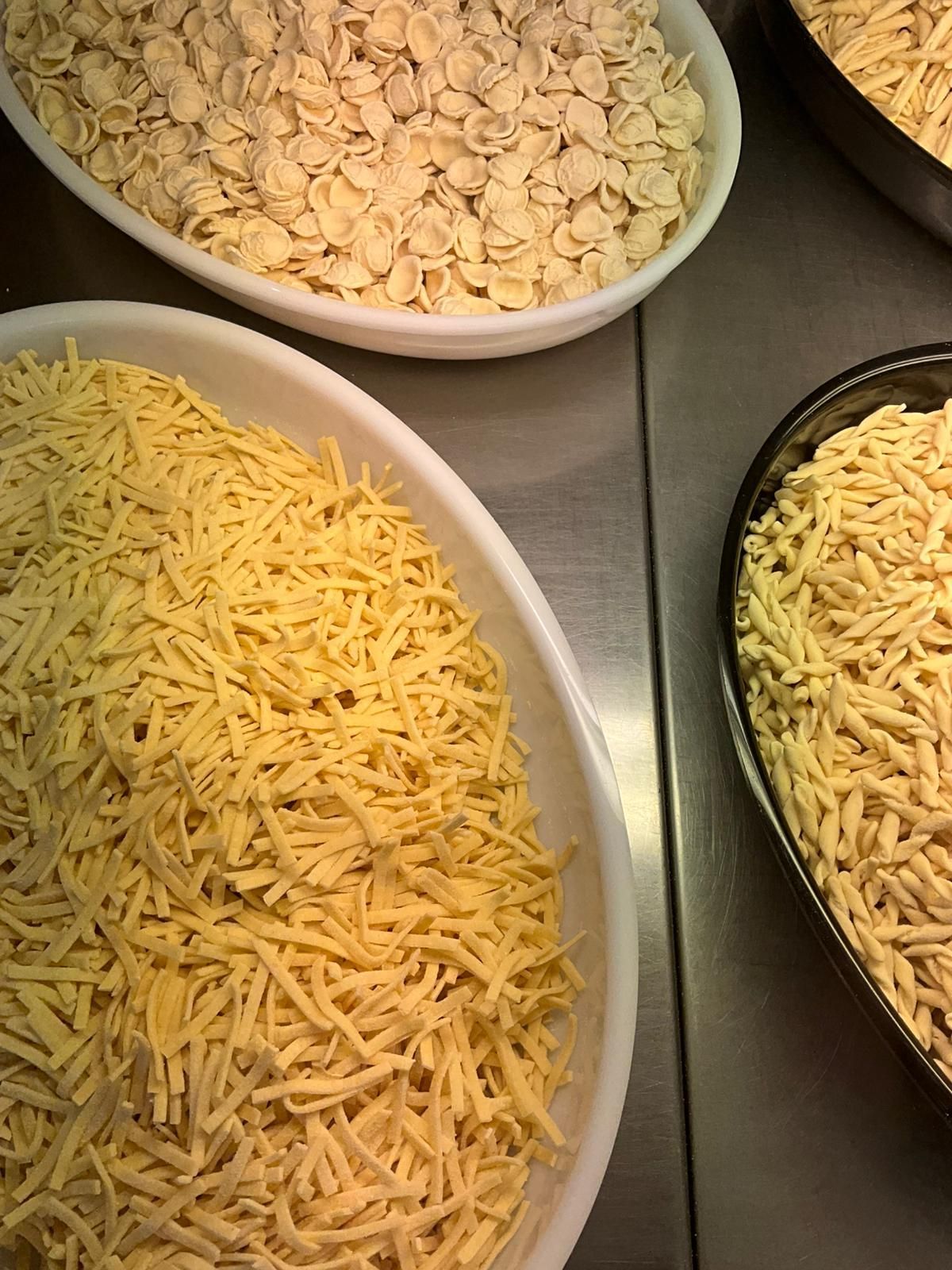 Primo piano di ravioli freschi infarinati; logo Santa Giorgio in un angolo.