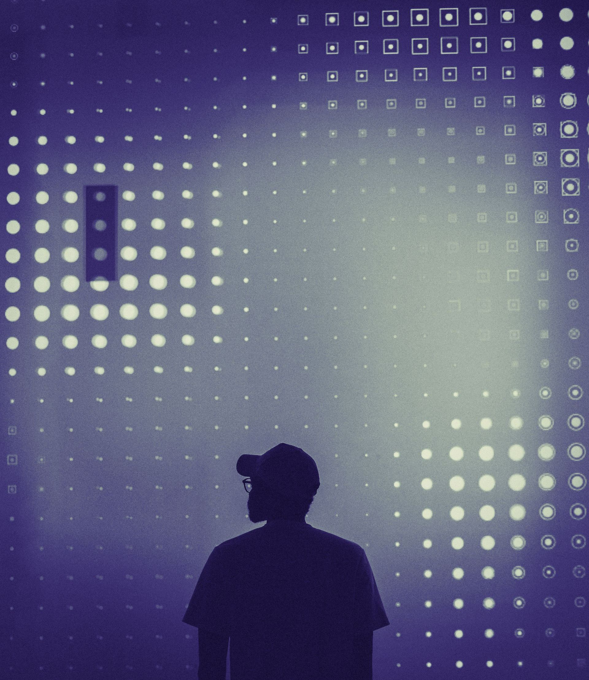 Person in silhouette standing before a wall of glowing dots, a purple hue.