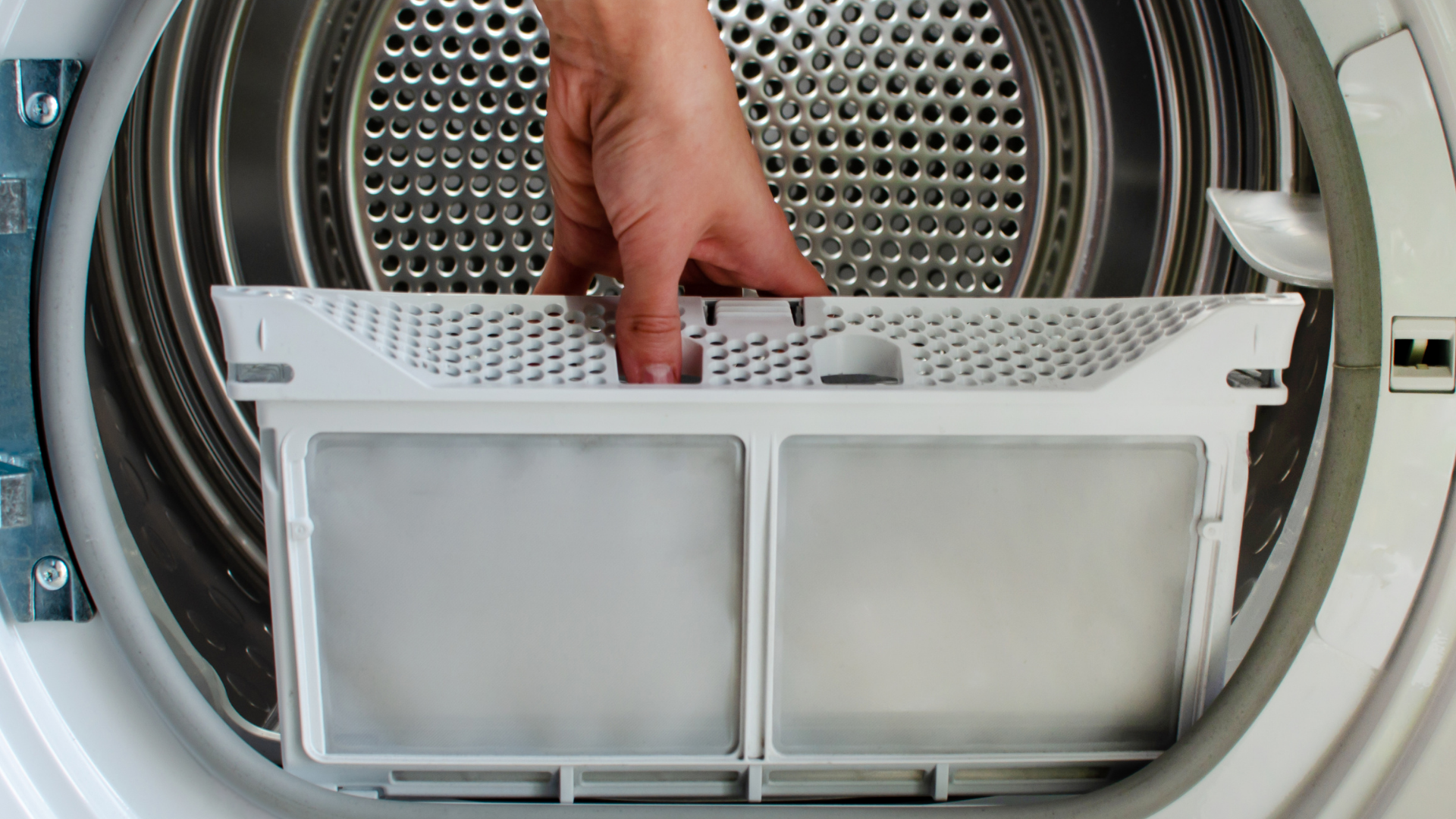 Person removing a lint filter from a clothes dryer.