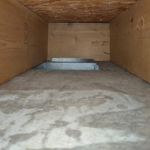 The inside of a wooden box with a concrete floor