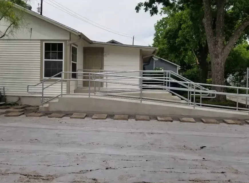 A white house with a ramp in front of it