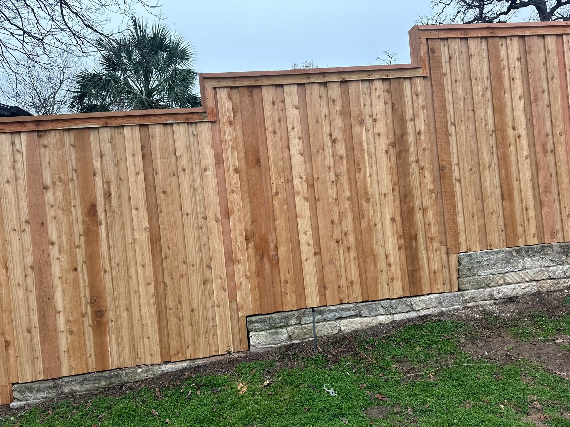 A wooden fence is sitting on top of a lush green field.