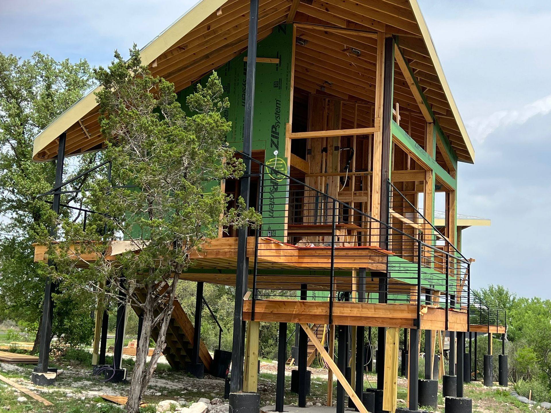 A house is being built on stilts in the middle of a forest.