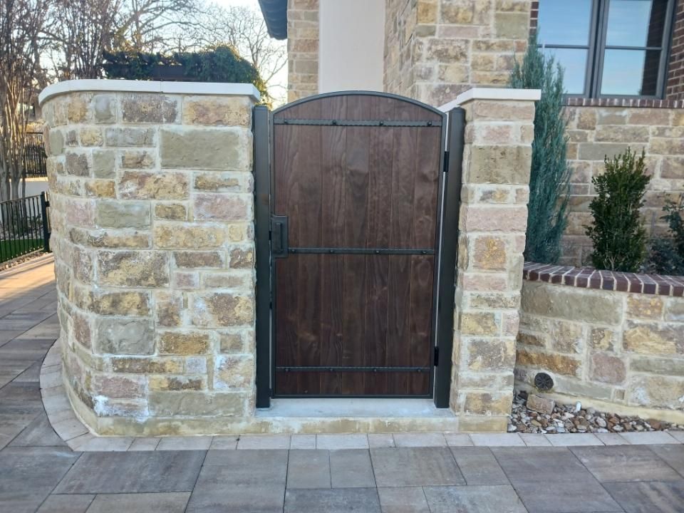 A stone wall with a wooden gate in front of it