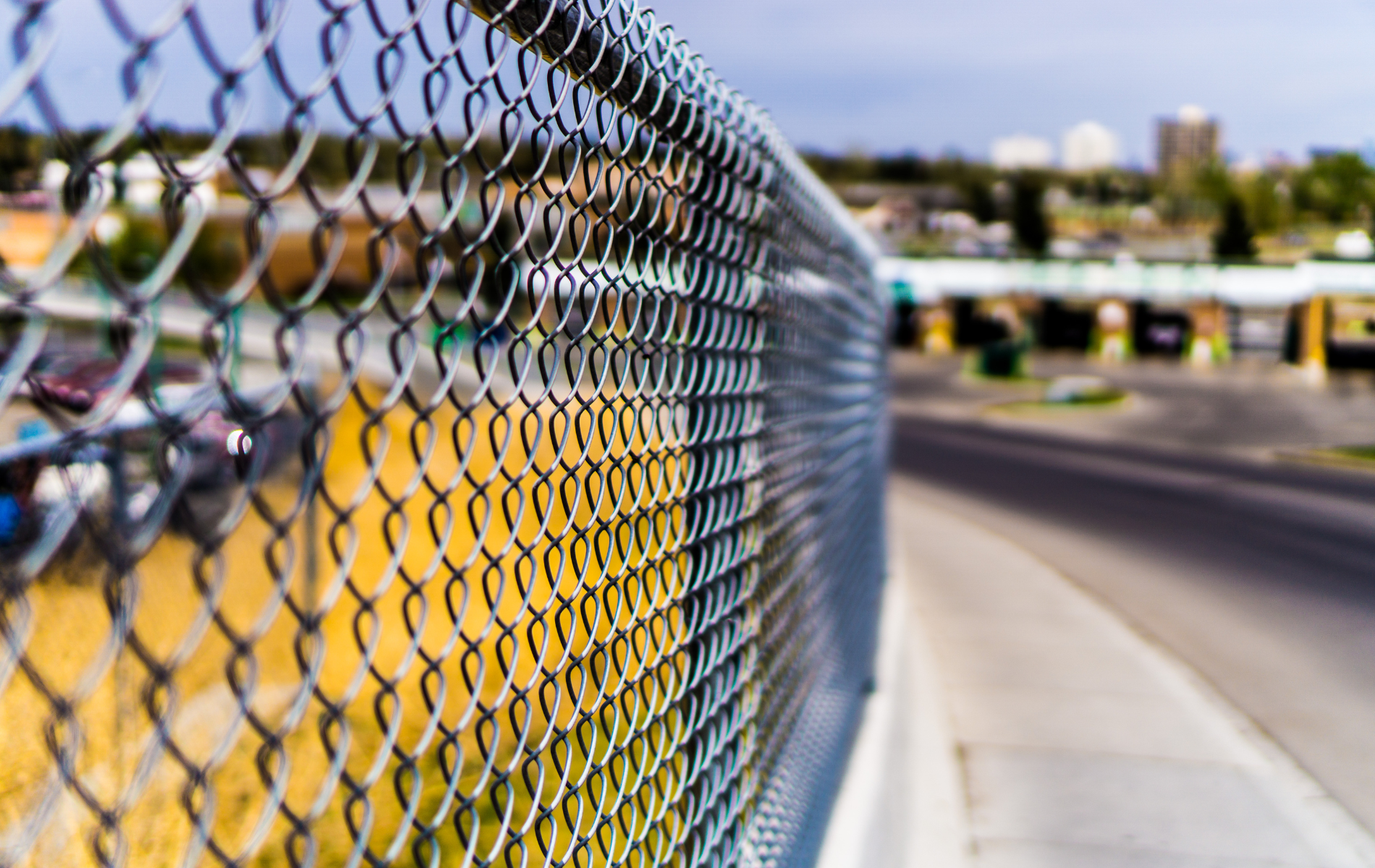 A close up of a chain link fence on a bridge.