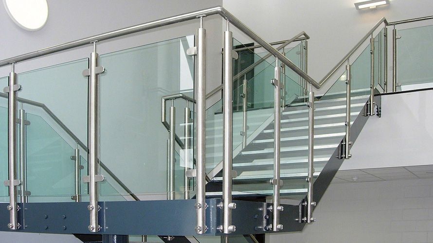 A staircase with a stainless steel railing and a glass railing