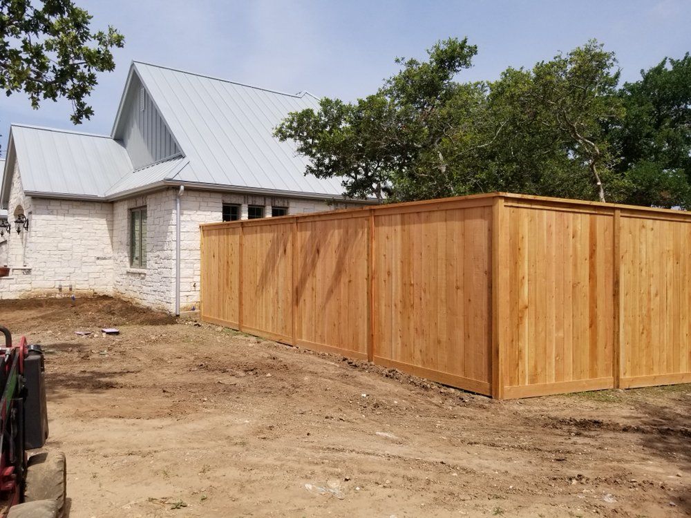 A wooden fence is being built in front of a house.