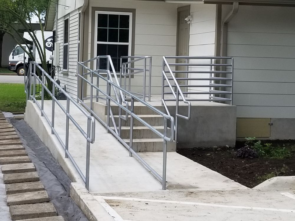 A ramp with stairs leading up to a white house