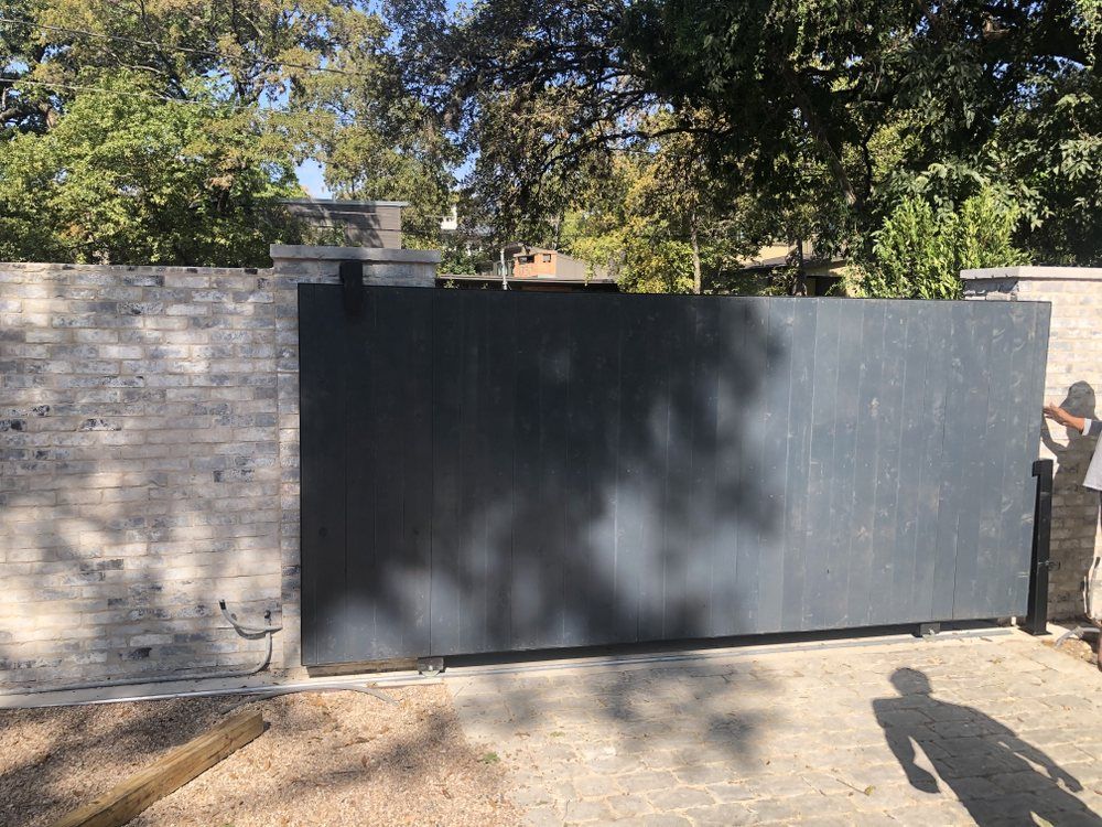 A brick wall with a sliding gate in front of it.