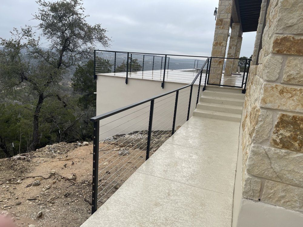 A staircase leading up to a balcony with a black railing