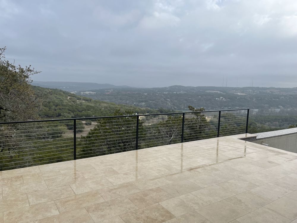 A balcony with a view of a valley and mountains.