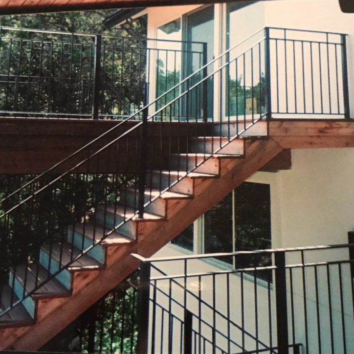A set of wooden stairs with a metal railing
