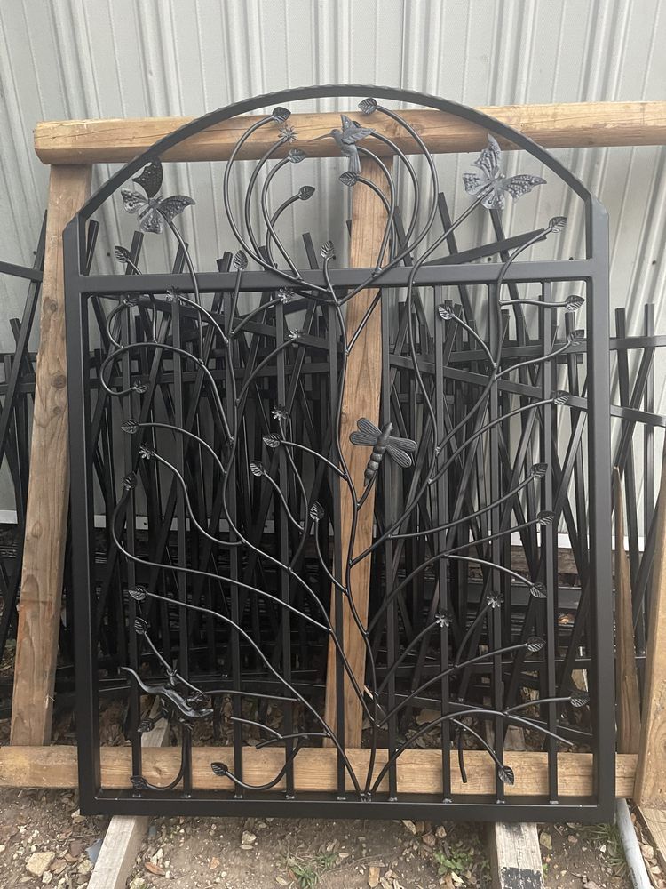 A wrought iron gate is sitting on top of a wooden pallet.