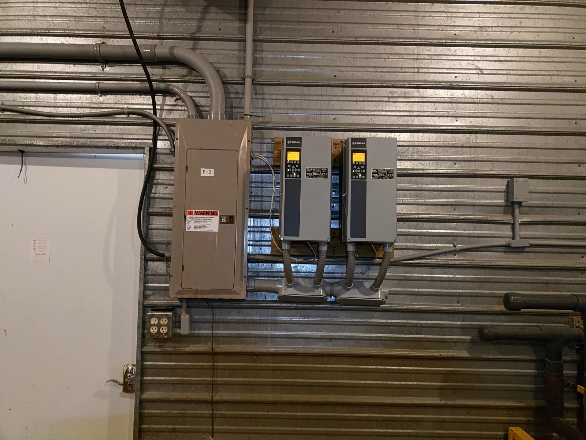 Two Electrical Boxes are Hanging on a Metal Wall — Union City, IN — Wiley Water Systems