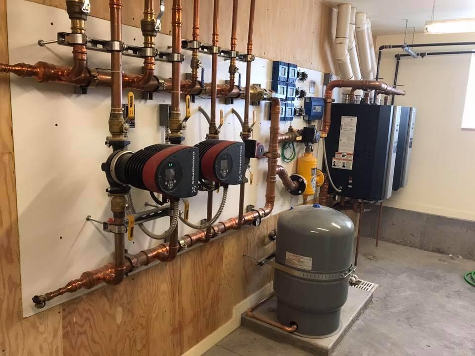 A room with a lot of pipes hanging on the wall.