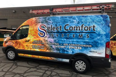 A select comfort systems van is parked in front of a building.
