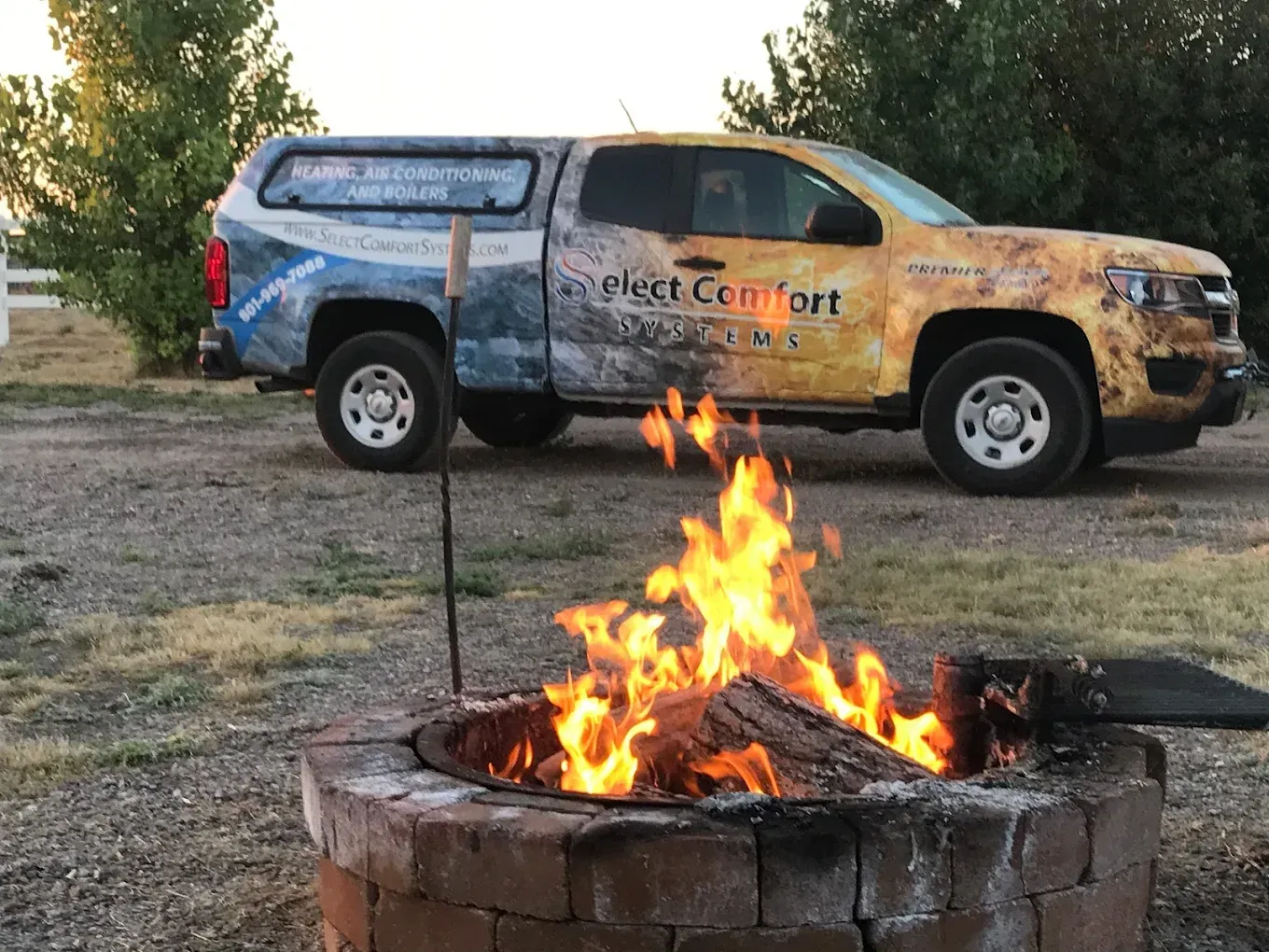 A truck that says pest comfort is parked next to a fire pit