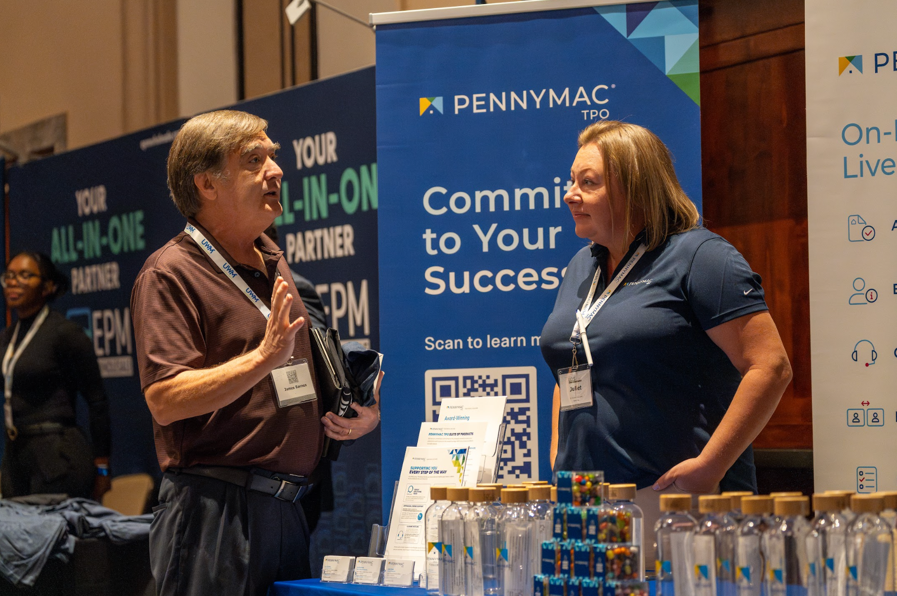 A man and a woman are standing in front of a sign that says commit to your success.