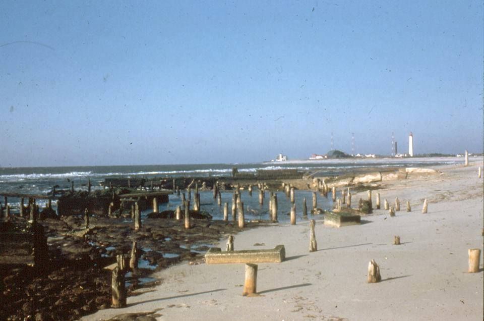 A beach scene with a lighthouse in the distance