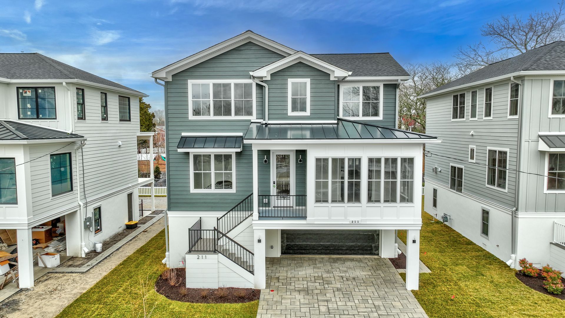 A large house with a lot of windows is sitting next to a smaller house.