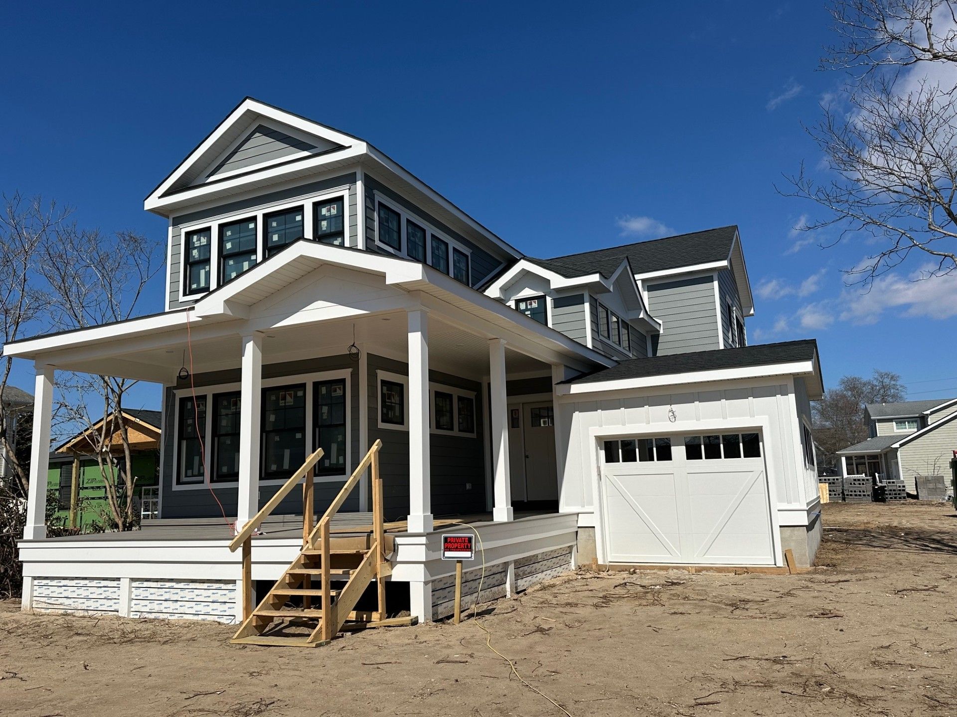 A large house with a large porch and stairs is for sale.
