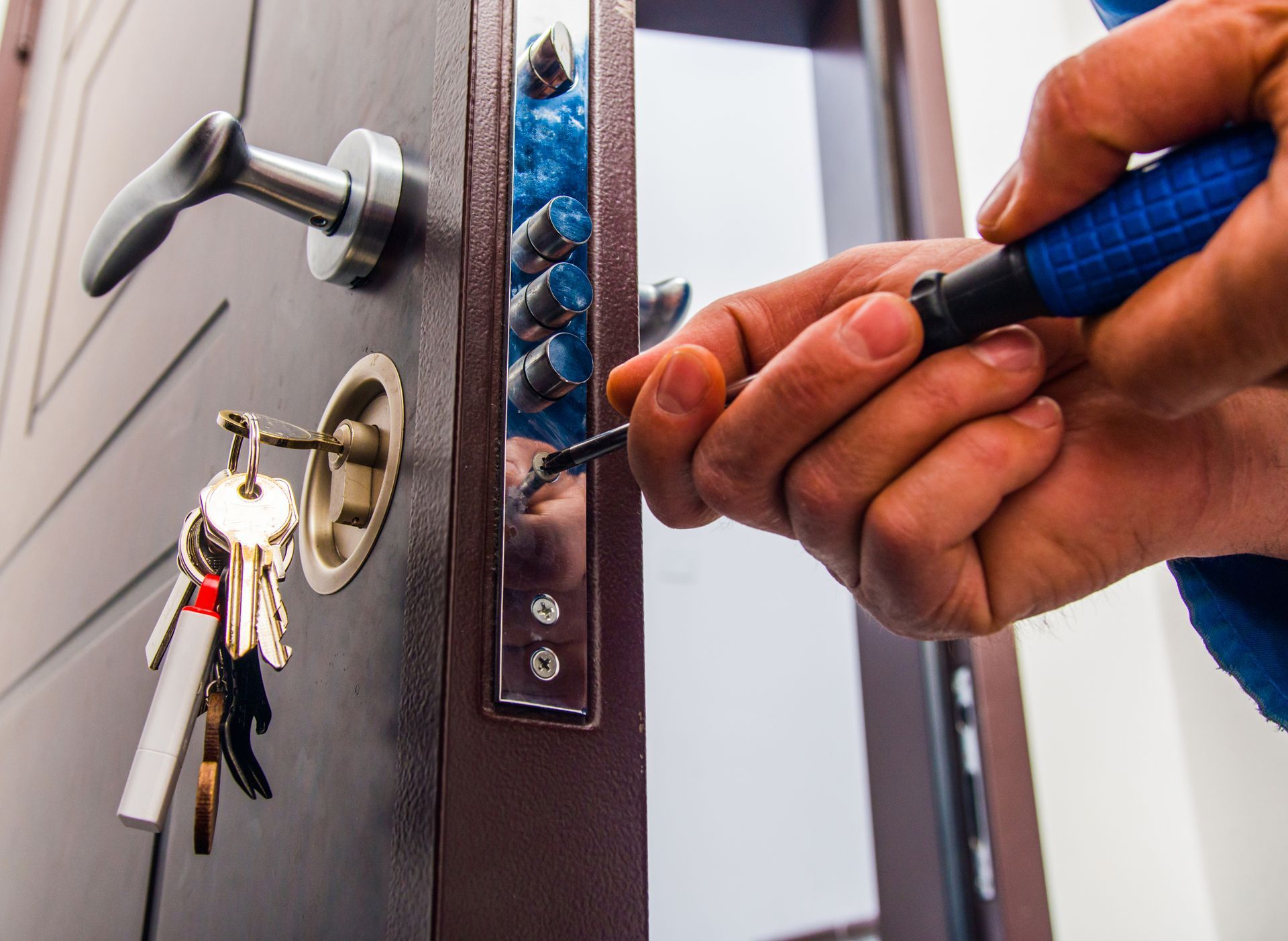 A handyman fixing a door lock with tools and equipment.