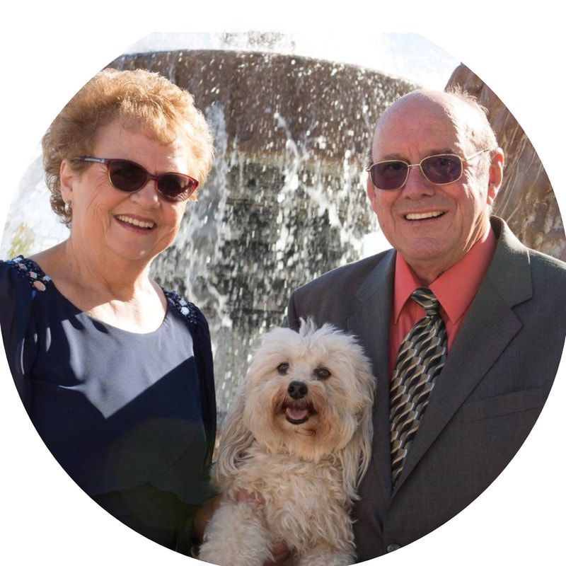 A man and woman are posing for a picture with their dog