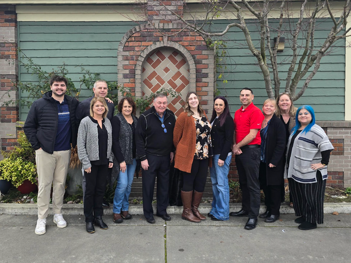 A group of people are posing for a picture in front of a building.