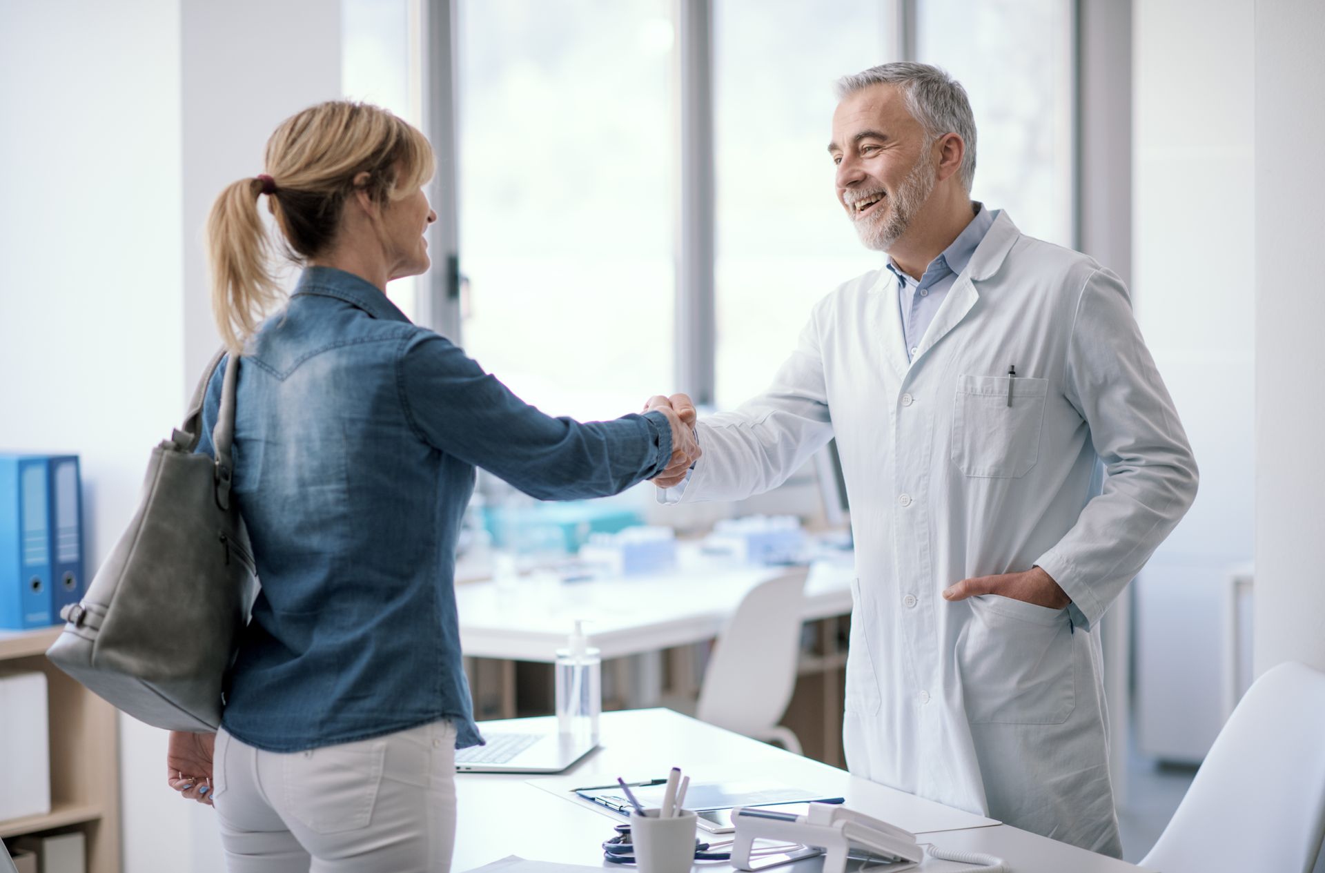 Doctor welcoming a patient in his office. Doctor welcoming a patient in his office.
