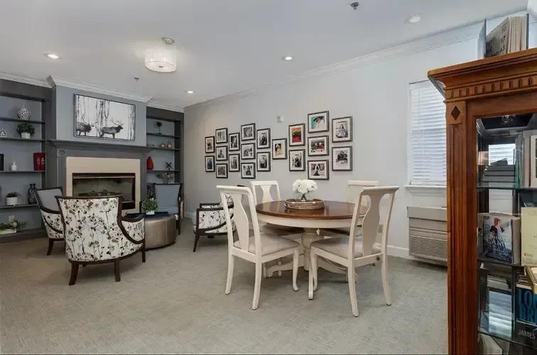 A living room with a table and chairs and a fireplace.