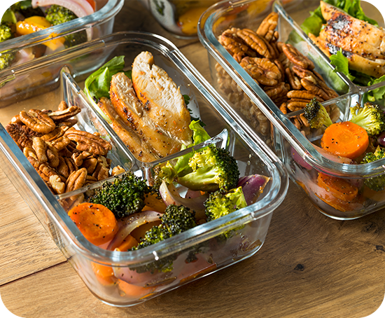 Three glass containers filled with different types of food on a wooden table.