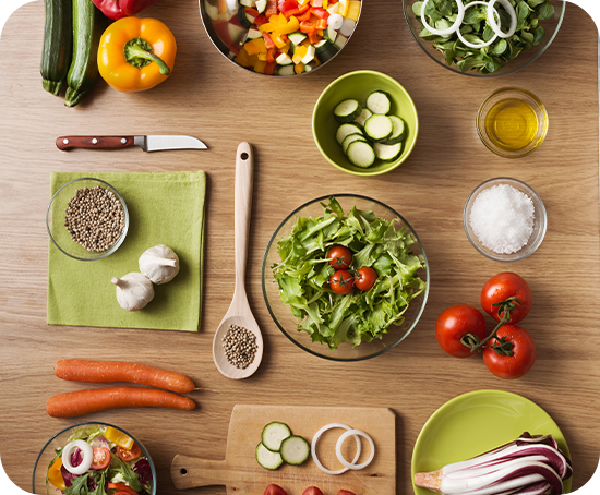 A wooden table topped with bowls of vegetables and a cutting board.