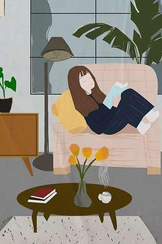A woman is laying on a couch reading a book.